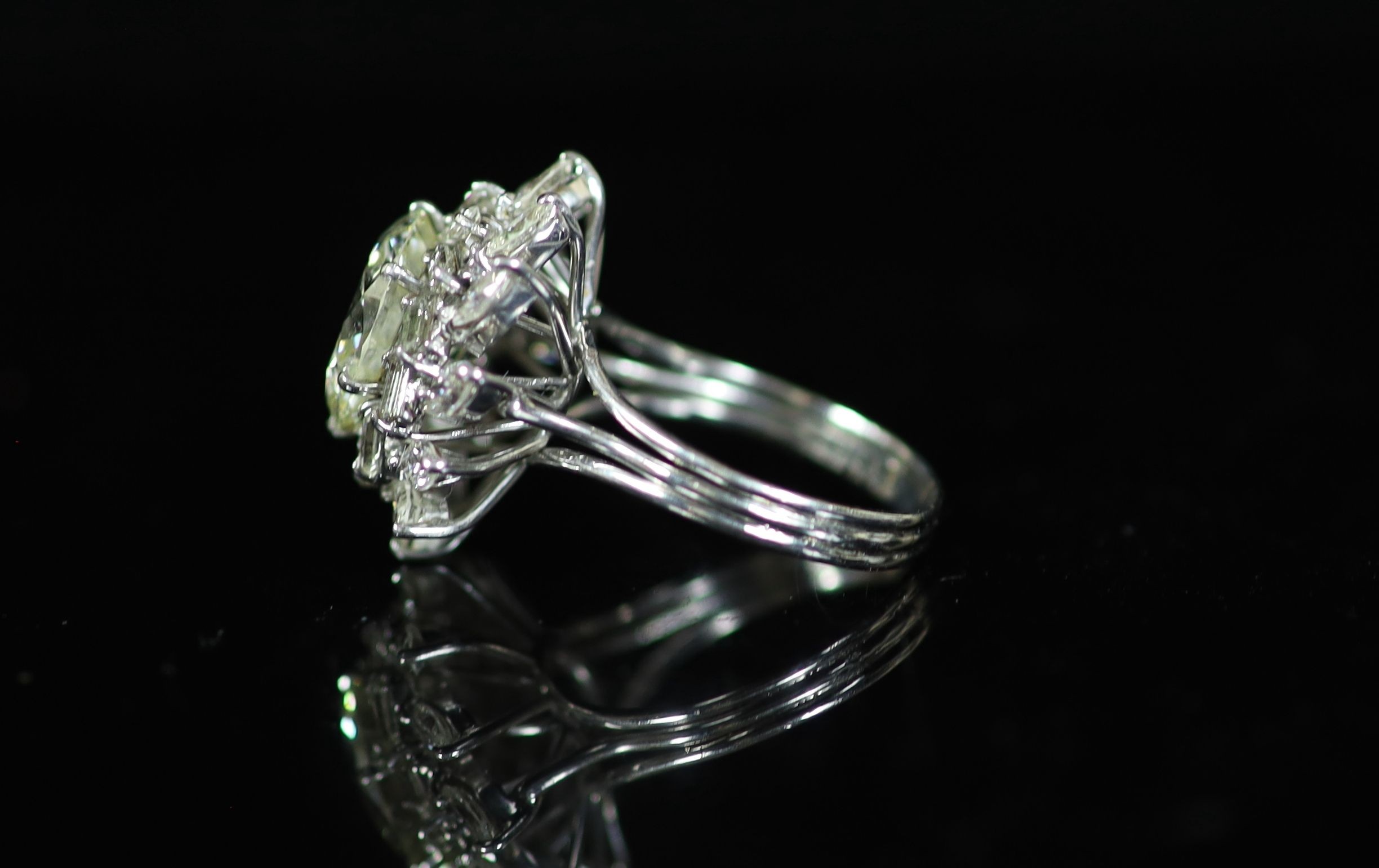 A platinum and single stone diamond ring, with baguette and marquise cut diamond foliate setting